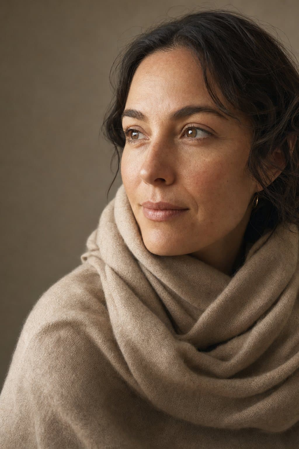 Warm portrait, shoulders up, gentle self-possessed calm. Illustrative image — not a patient.