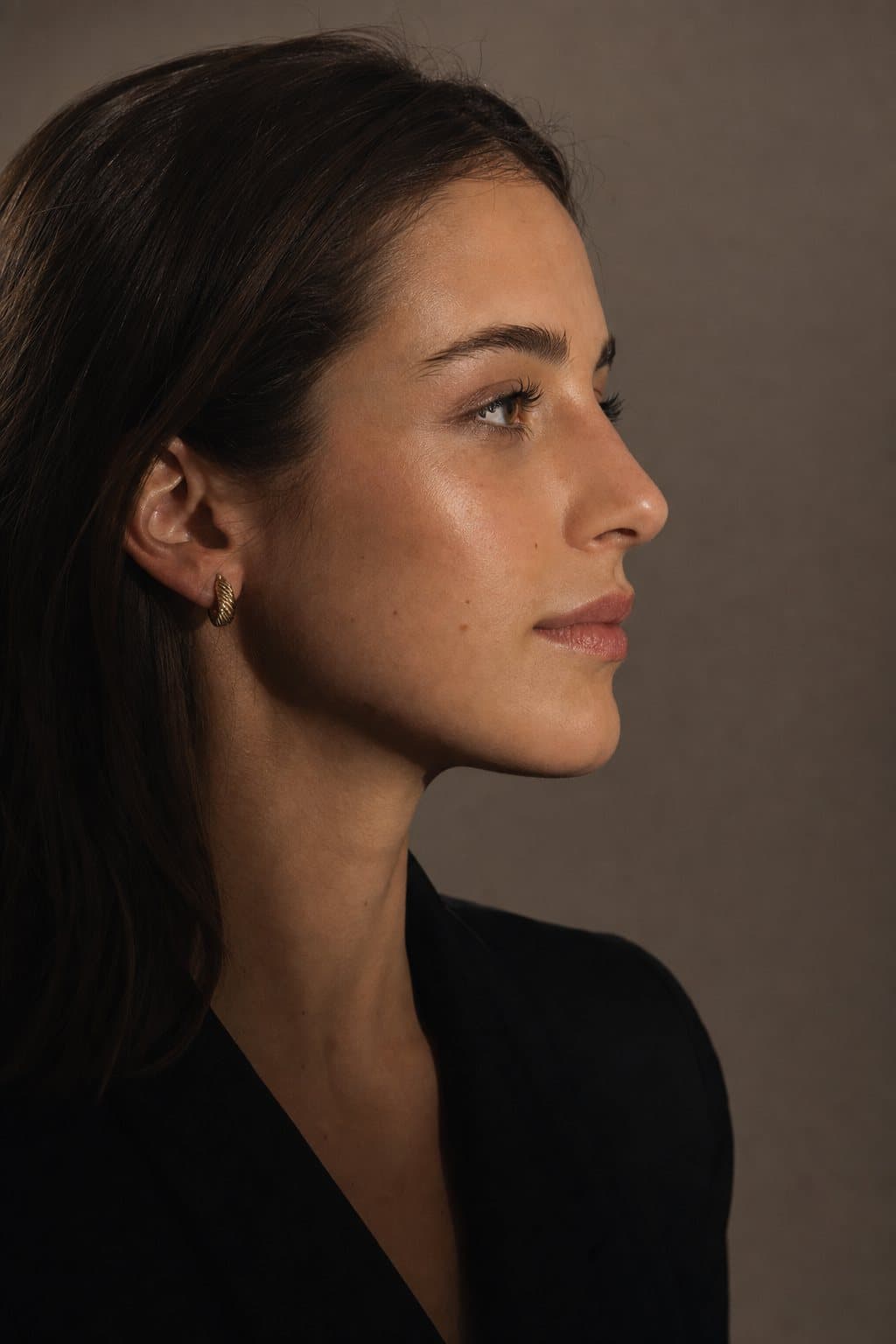 Elegant profile with hair swept behind the ear. Illustrative image — not a patient.