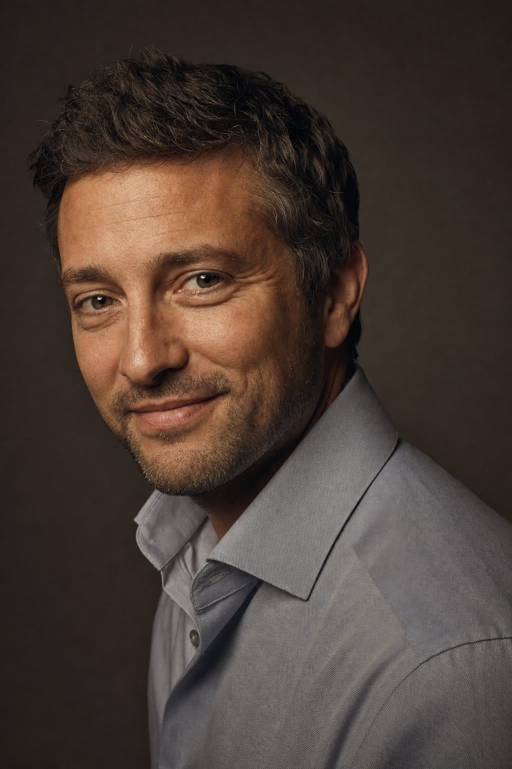 Approachable three-quarter portrait of a man, warm light along the jaw. Illustrative image — not a patient.