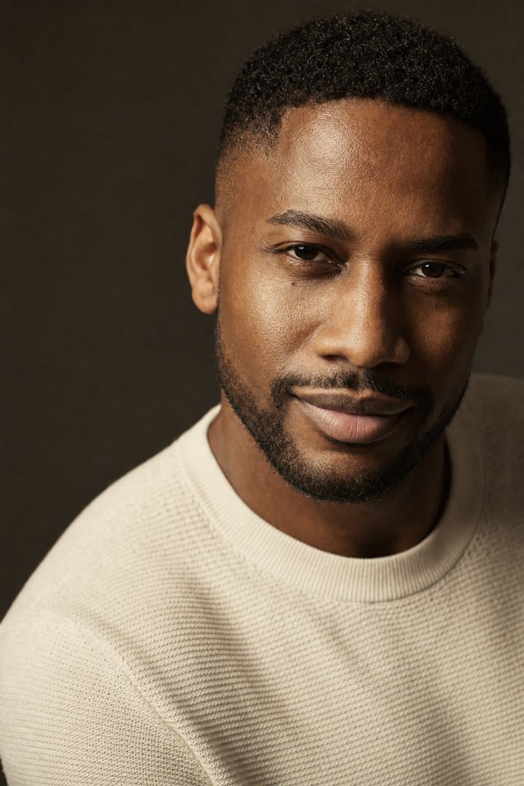 Athletic male portrait, caught half-smile. Illustrative image — not a patient.