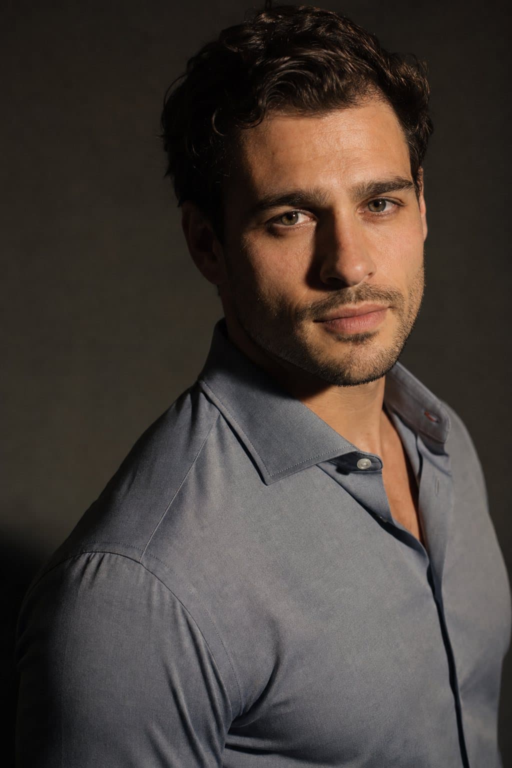 Confident male portrait, level gaze, strong light. Illustrative image — not a patient.