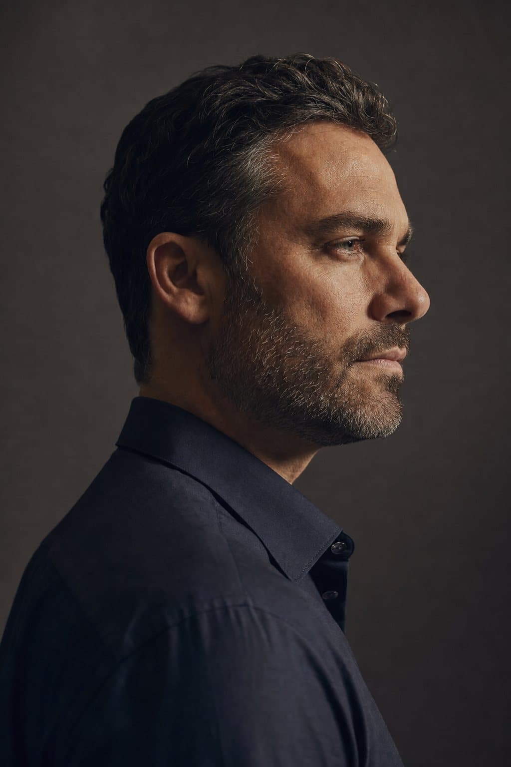 Refined male profile in raking light. Illustrative image — not a patient.