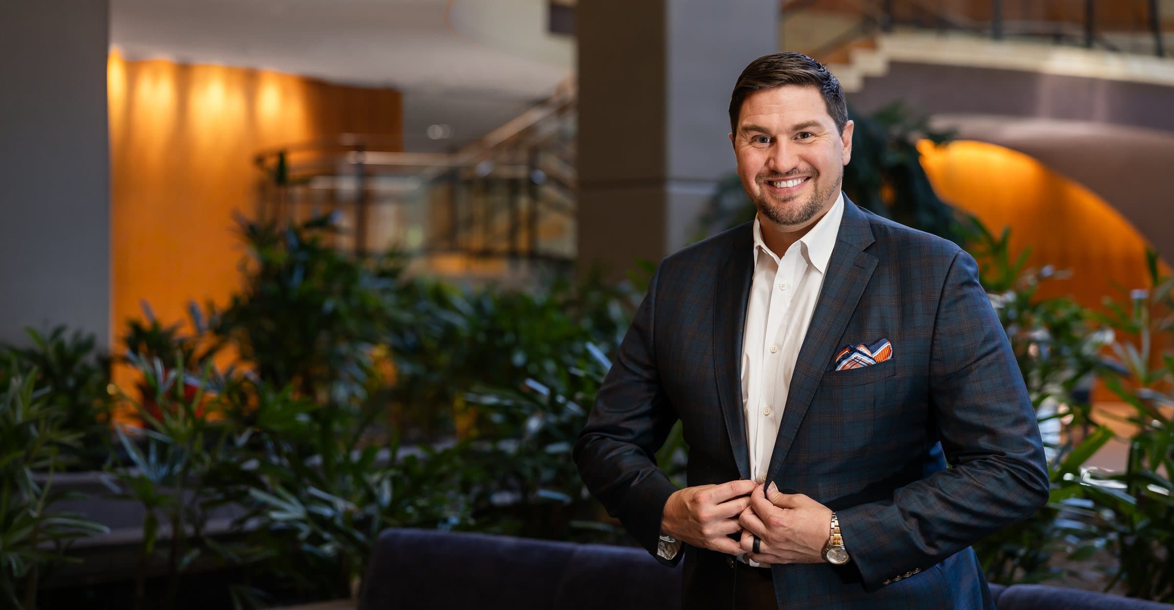 Kristopher M. Day, MD, FACS, standing in the atrium at Pacific Sound Plastic Surgery in Bellevue